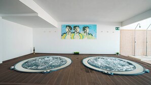A spa room with two hot tubs, a wall painting, and a tiled shower area. - Ohtels Cabogata (Almeria)