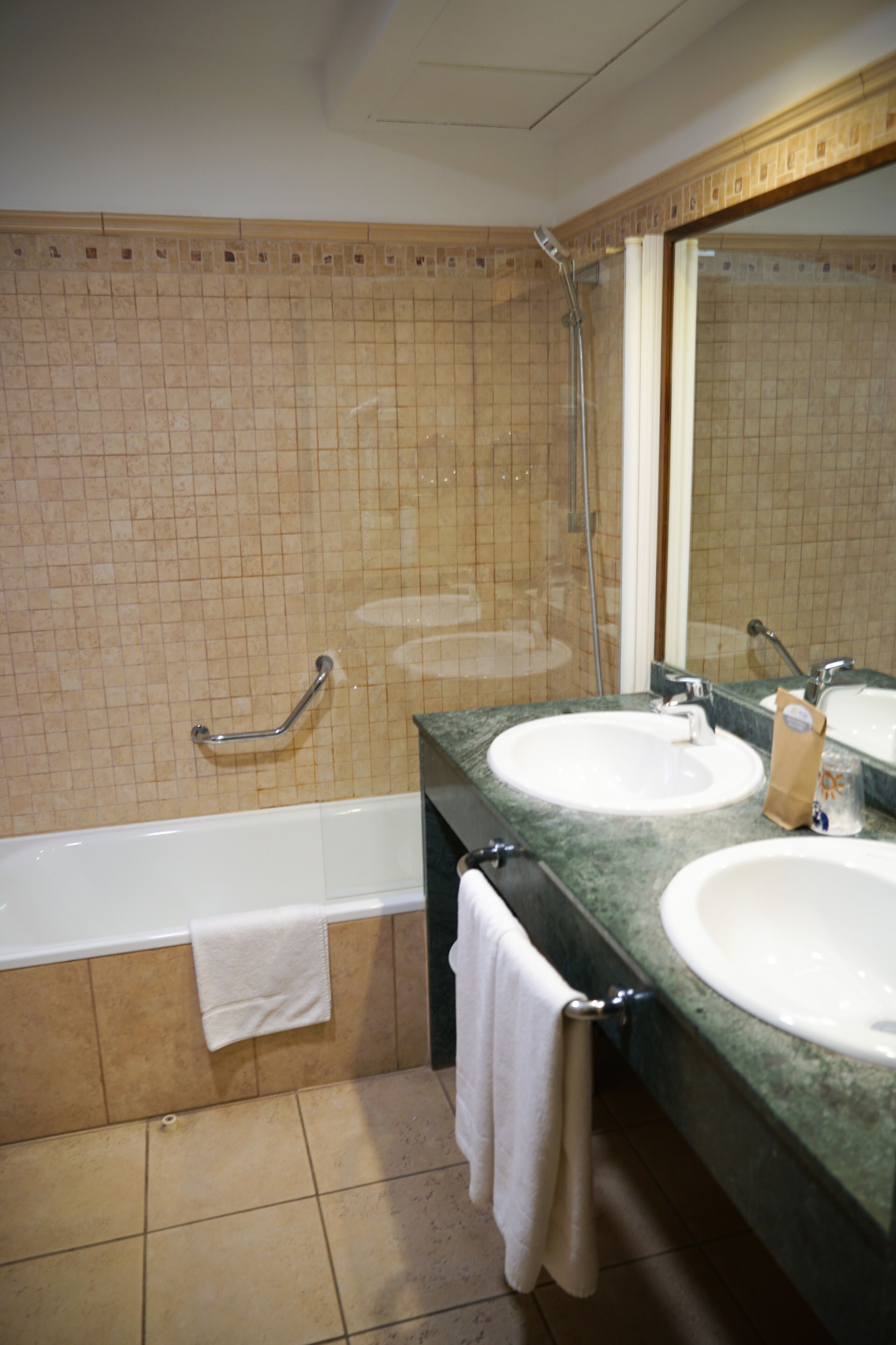 A bathroom with two sinks, a bathtub, and a shower.