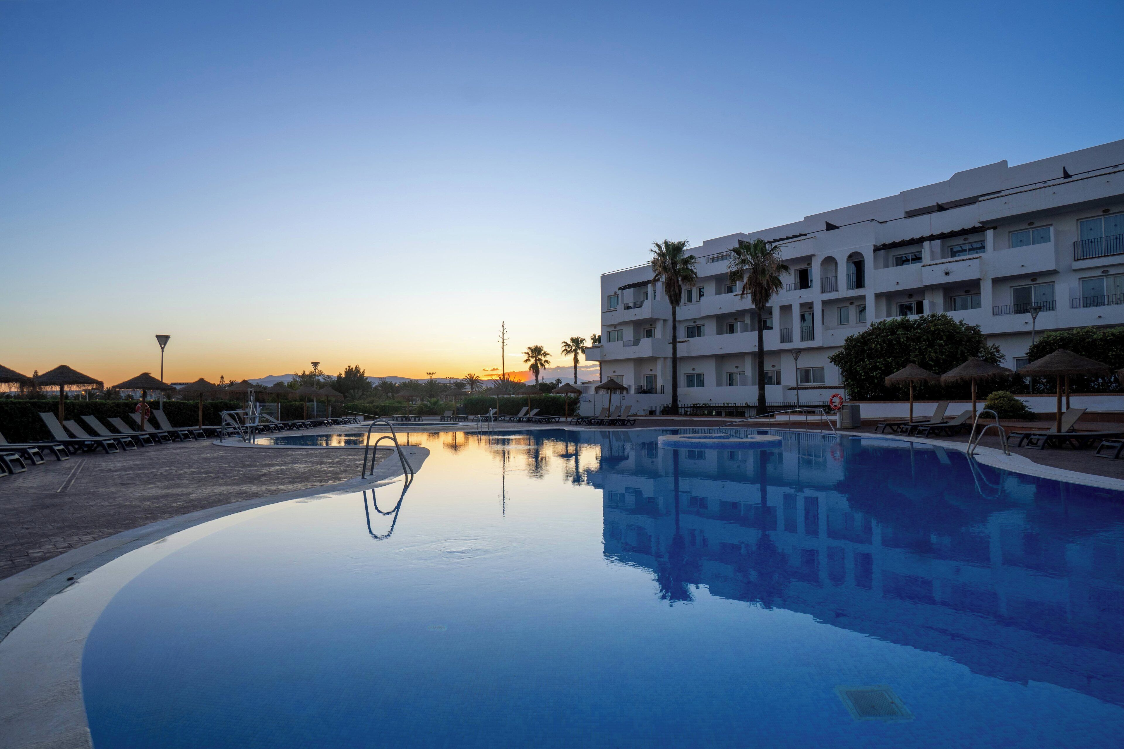 Een binnenzwembad, een buitenzwembad en ligstoelen