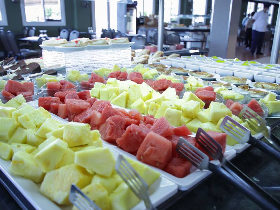A buffet with various fruits and a dining area in the background.