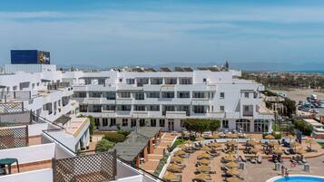 Een binnenzwembad, een buitenzwembad en ligstoelen