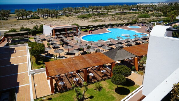 A resort with a large pool, outdoor seating, and a view of the ocean. - Ohtels Cabogata (Almeria)