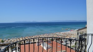 Un balcon avec vue sur une plage et la mer.