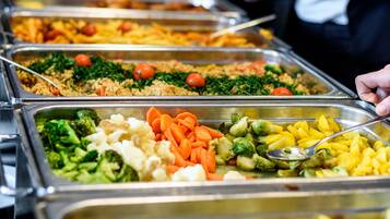 A buffet with various food options including rice, vegetables, and fruits.