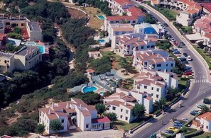 Residential neighborhood with single-family homes and apartment buildings along a curved road.