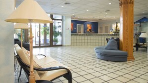 A lobby with a reception desk, a blue sofa, a wooden pillar, and a lamp. - Jaime I Hotel Peñiscola (Peniscola)