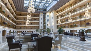 A spacious atrium with multiple balconies, elegant chandeliers, and plush seating areas. - Club Hotel Phaselis Rose - All Inclusive (Kemer)