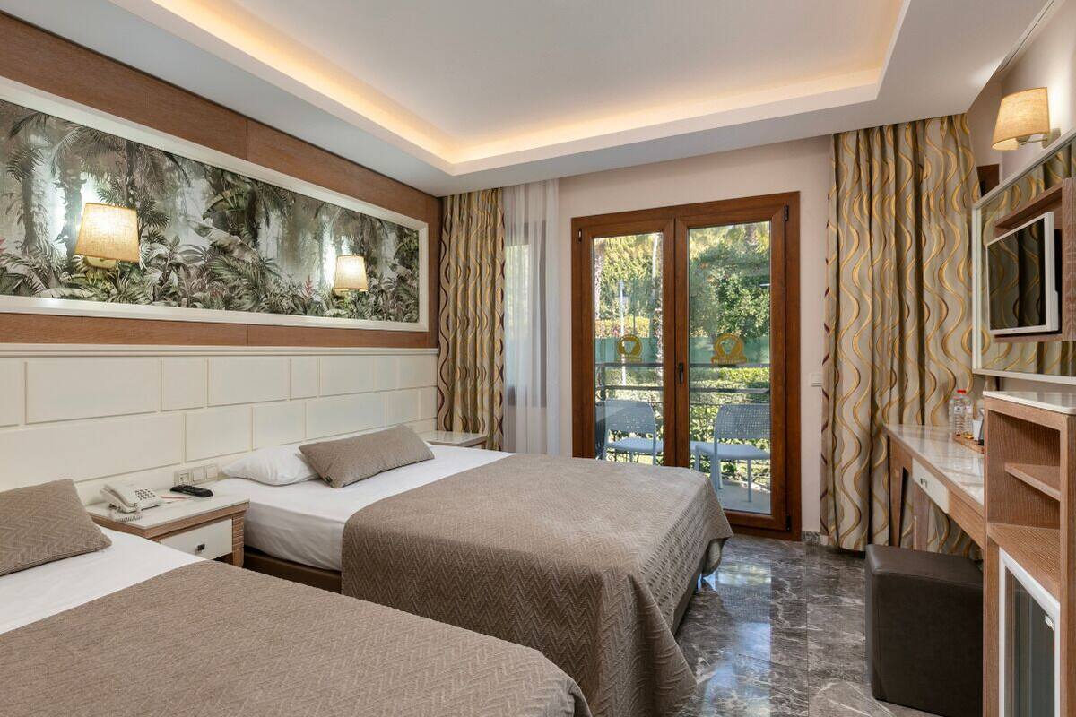 A hotel room with two beds, a large mural on the wall, a TV, and a sliding glass door to the outside.