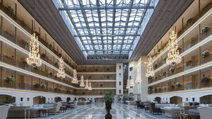 A spacious atrium with a high ceiling, multiple balconies, and chandeliers. - Club Hotel Phaselis Rose - All Inclusive (Kemer)