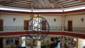 Un vaste atrium doté d’un haut plafond et d’un grand lustre sphérique. On y trouve plusieurs niveaux avec des balcons, ainsi qu’une variété de boutiques au rez-de-chaussée.