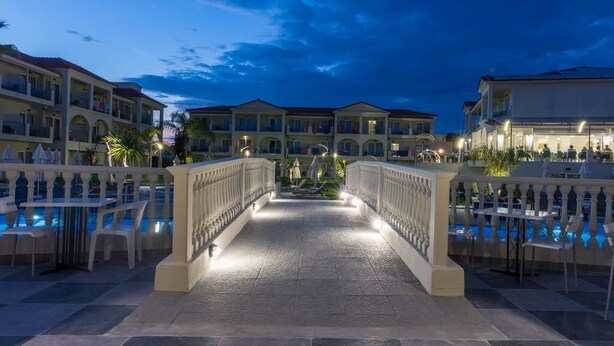 A hotel with a central pool area, multiple balconies, and a covered walkway. - Exotica Hotel (Zakynthos)