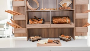 A wooden display case with various baked goods and bread. - Exotica Hotel (Zakynthos)