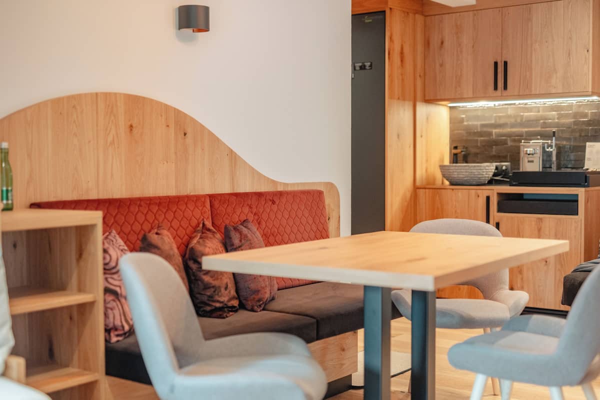 A modern kitchen with wooden cabinets, a built-in oven, and a countertop with a coffee machine.