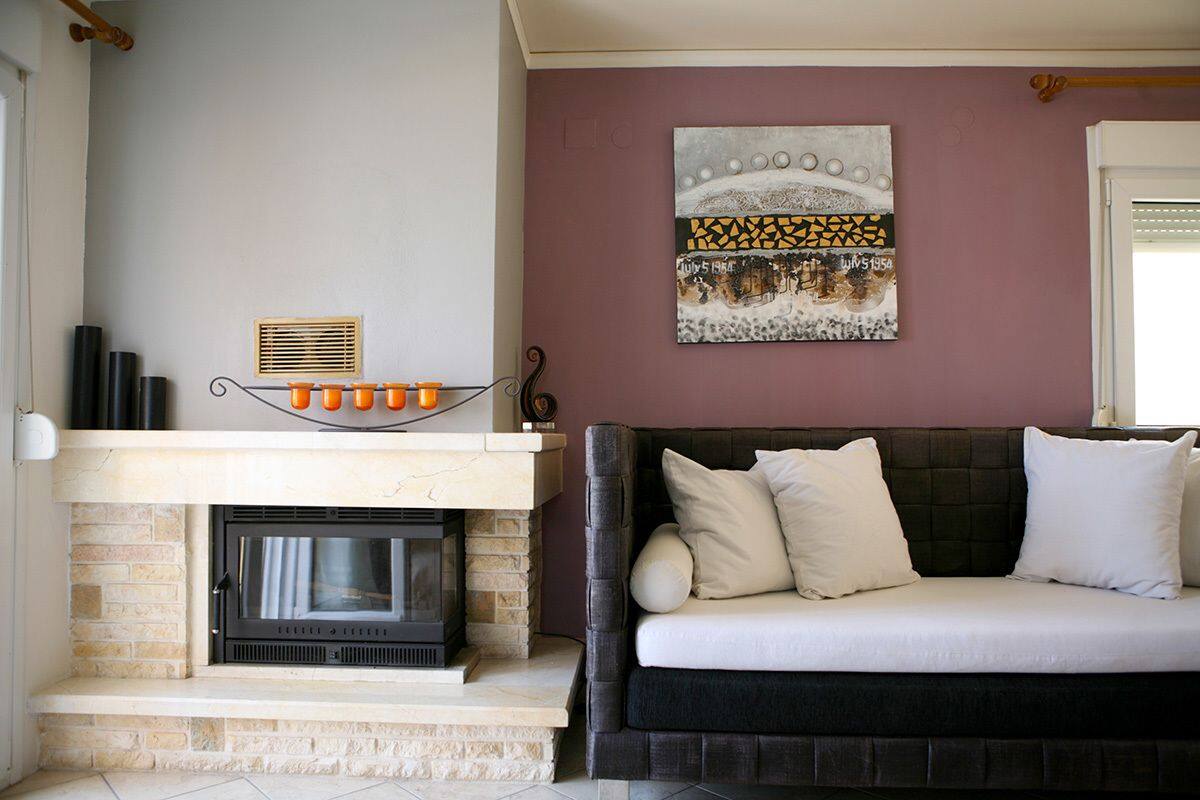 A living room with a fireplace, a sofa, and a wall-mounted artwork.