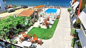 Área da piscina com assentos ao ar livre e vista para o mar.