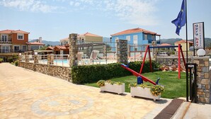 Hotel com área de piscina, espaço para sentar ao ar livre e uma bandeira.