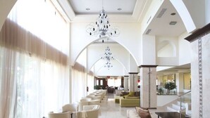 A spacious lobby with high ceilings, a grand chandelier, and a modern staircase. - Ialyssos Bay (Rhodes)