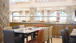 A dining area with a long counter, multiple seating options, and a view of the kitchen area. - Ialyssos Bay (Rhodes)