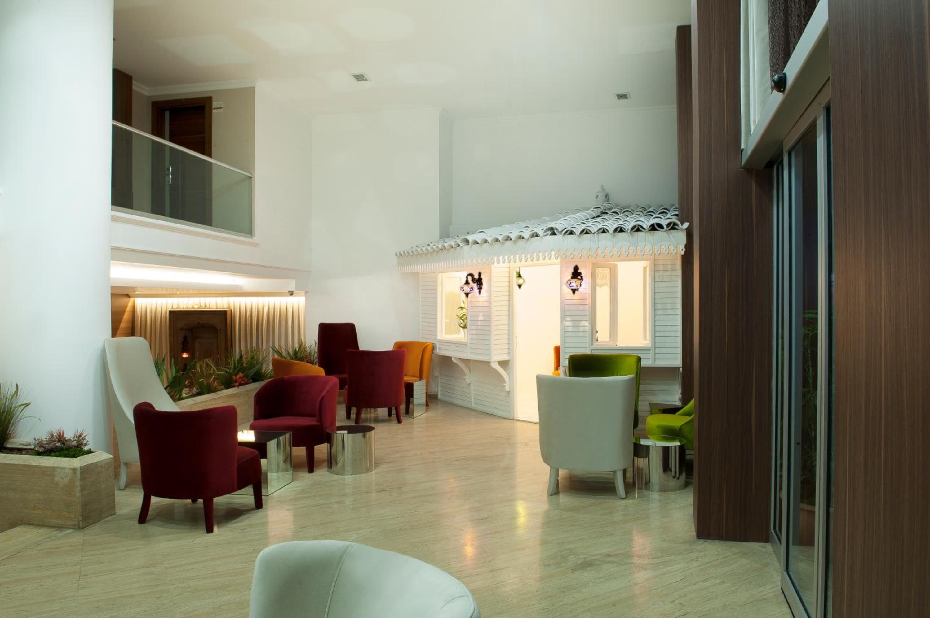 A spacious lobby with modern furniture, a staircase, and a decorative ceiling.