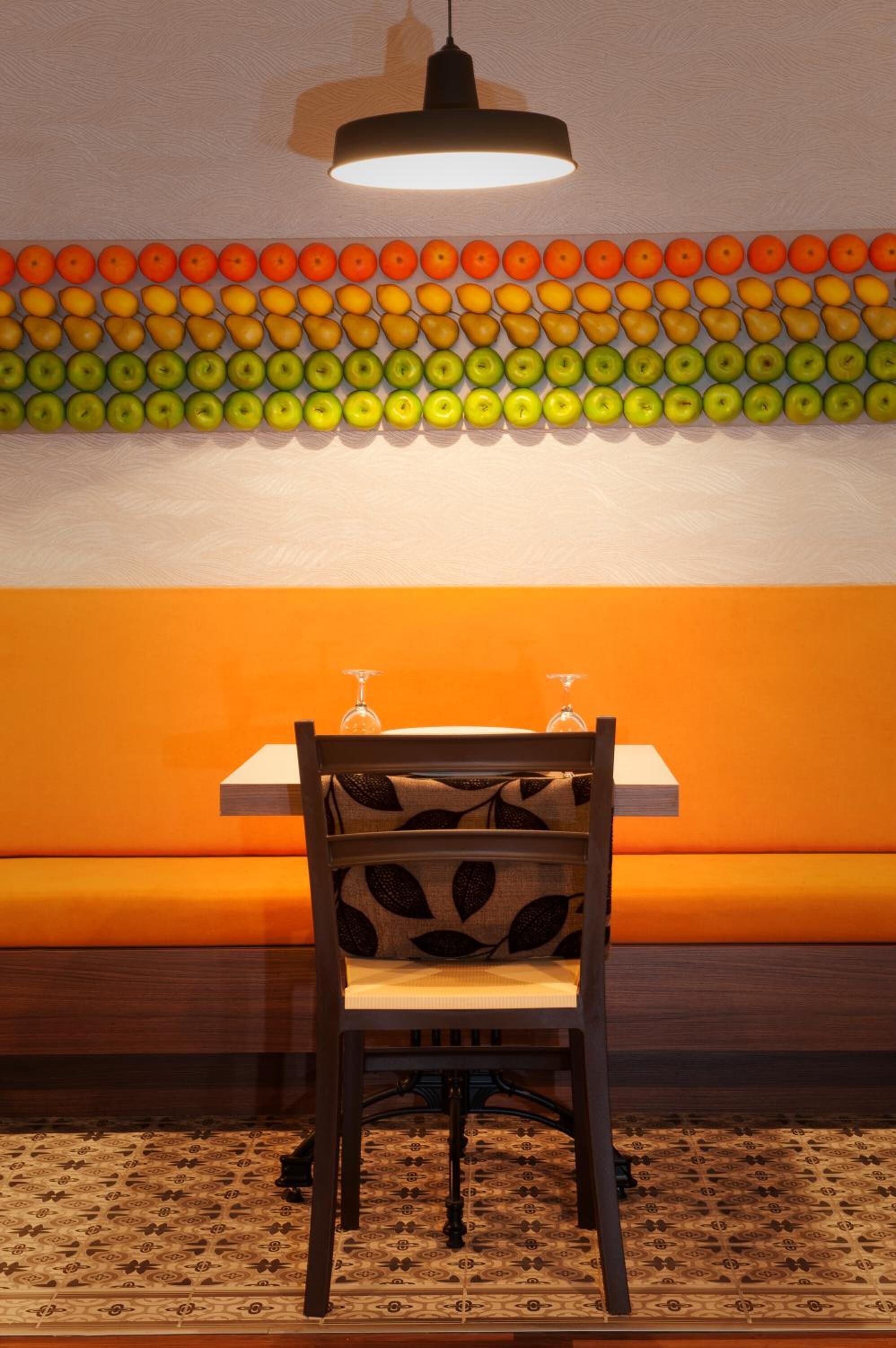 A dining area with a table and chairs, a patterned wall, and a hanging light fixture.