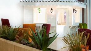 Un área de recepción con interior blanco, techo de tejas y una exhibición de plantas.