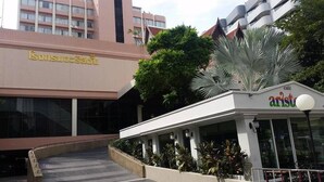 A building with a sign reading "Southeast Asia" and a cafe named "Cafe Aristotle" with outdoor seating. - The Ariston (Bangkok)
