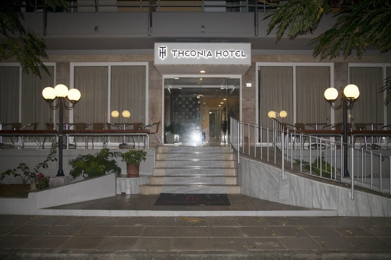 L’entrée de l’hôtel Theonia se distingue par un escalier en marbre, des plantes en pot et une rampe en métal.