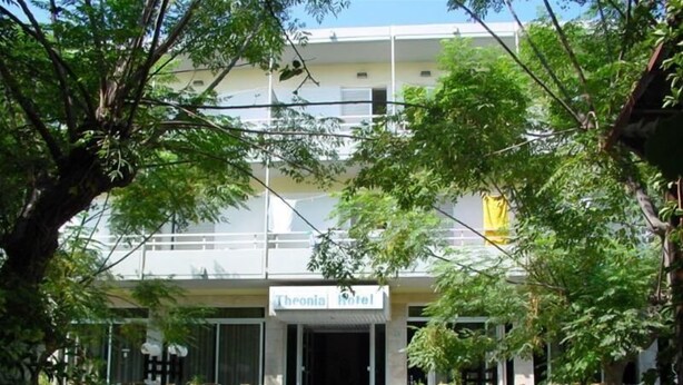 A hotel named Theonia Hotel with a modern facade, visible balconies, and a parked scooter in front. - Theonia (Kos)