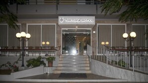 The entrance of Theonia Hotel with a marble staircase, potted plants, and outdoor seating. - Theonia (Kos)