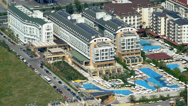 Eine Luftaufnahme eines Hotels mit mehreren Gebäuden, einem Poolbereich und einem Parkplatz.