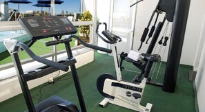 A gym with a treadmill, an elliptical, and a stationary bike. - Embajador (Montevideo)
