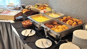 Un bufé con diversas opciones de comida, como pasteles, frutas y huevos.