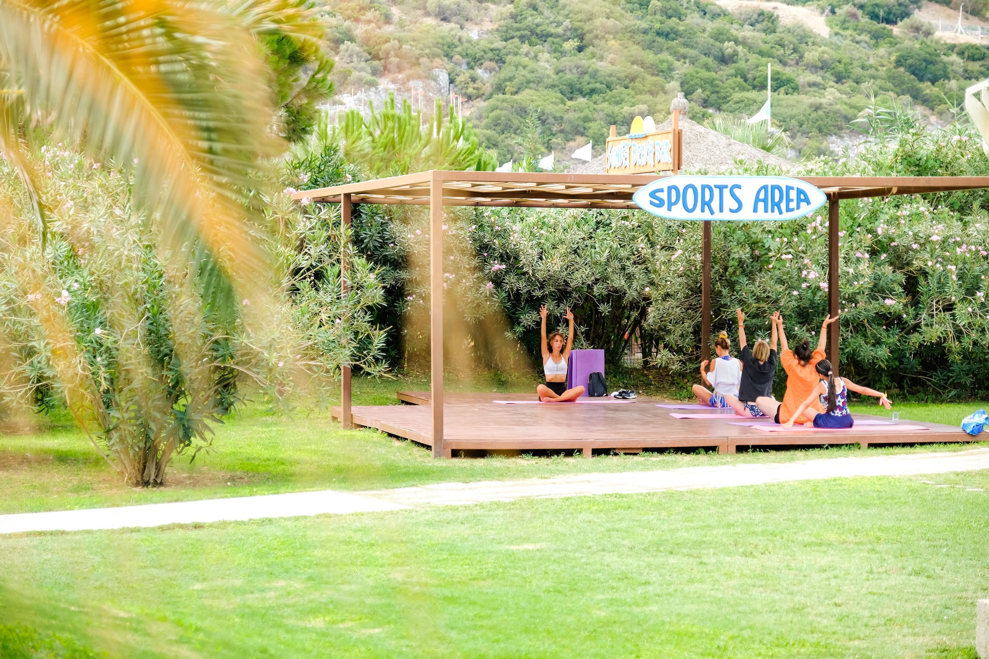 Un espace dédié aux activités sportives, doté d’une pergola en bois et d’un panneau d’identification.