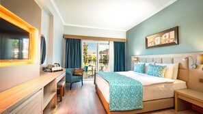 A hotel room with a bed, a desk, a chair, a TV, and a balcony with curtains. - Aqua Fantasy Aquapark Hotel & Spa - All Inclusive (Selçuk)