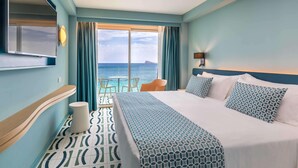 A hotel room with a large bed, a TV, a view of the sea, and a small table with chairs. - Selomar (Benidorm)