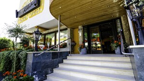 L’entrée d’un hôtel, avec une façade en bois, une enseigne et un escalier menant à l’entrée.