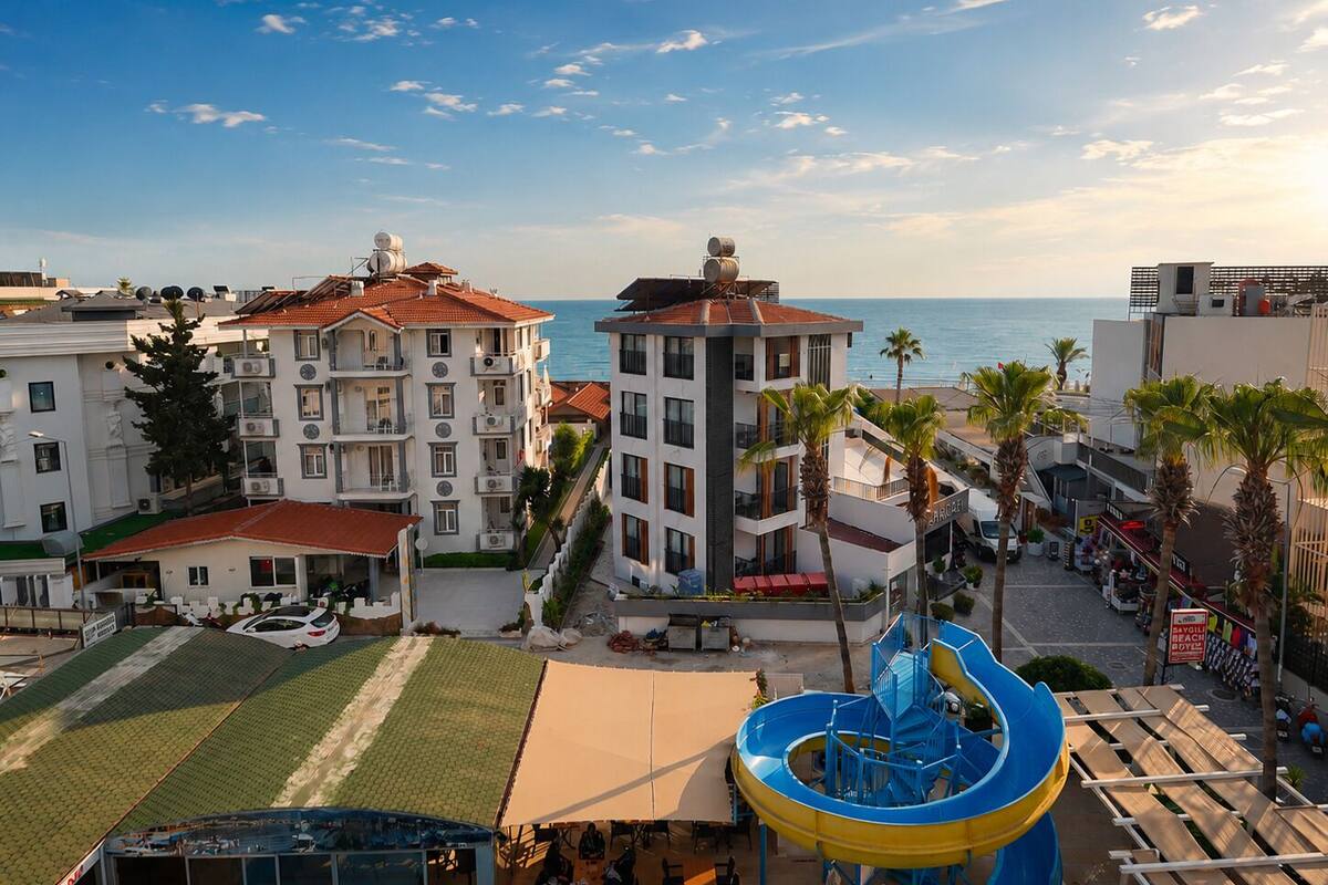 Ein Küstenhotel mit mehreren Etagen, einem Schwimmbad und Meerblick.