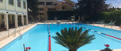 Una piscina al aire libre de temporada, sillones reclinables de piscina