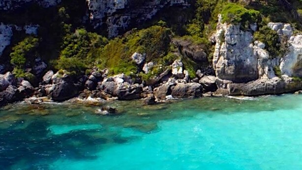 A coastal landscape with clear turquoise waters, rocky cliffs, and a sandy beach. - Aparthotel Nuramar (Ciutadella de Menorca)