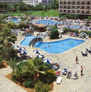 Un resort con varias piscinas, tumbonas y sombrillas.