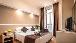 A hotel room with a bed, bedside table, TV, and a window with curtains. - Raeli Hotel Siracusa (Rome)