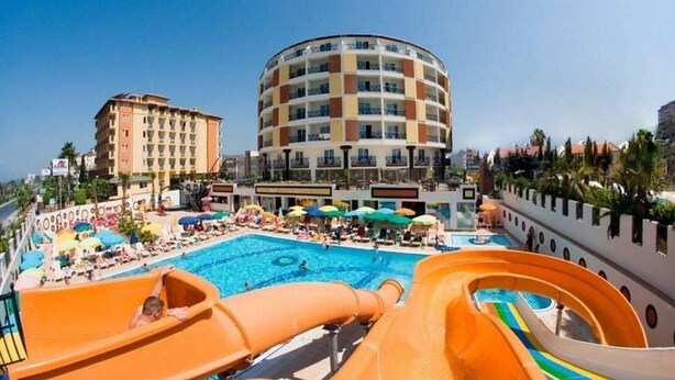 Et hotel med poolområde, vandrutsjebaner og solstole.
