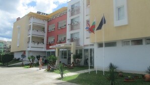 A hotel with a central entrance, multiple balconies, and a flag. - Hotel Belleville (Nessebar)