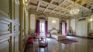 A grand room with ornate ceiling, a large bed, and a chandelier. - Hotel Sofia (Catania)