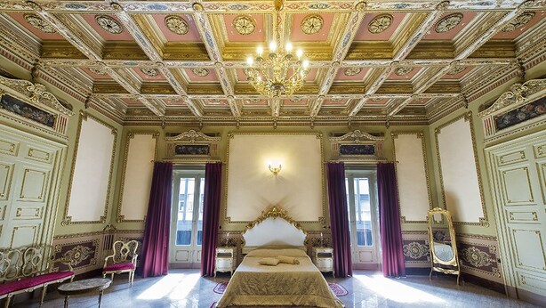 A grand bedroom with a large bed, ornate ceiling, and classic furniture. - Hotel Sofia (Catania)
