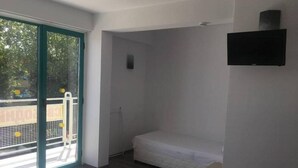 A modern room with a bed, a small desk, and a TV. - Largo (Sunny Beach)