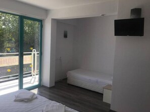 A modern room with a bed, a small desk, and a TV. - Largo (Sunny Beach)