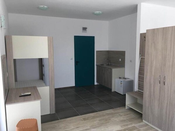 A compact kitchen with a sink, a small refrigerator, and a teal door. - Largo (Sunny Beach)
