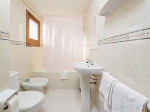 A bathroom with a toilet, bidet, sink, and bathtub. - Alicante (Sant Antoni de Portmany)