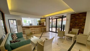 A spacious lobby with a sofa, chairs, a coffee table, and a bar area. - Eda Hotel (Marmaris)